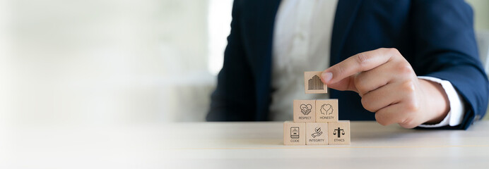 Code of conduct in business concept. Wooden blocks with code of conduct icons; code, integrity, honesty, respect, and ethics,  the foundation of a strong corporate code of conduct. Corporate ethics.
