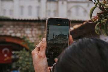 Tourist taking photo of the suleymaniye mosque in istanbul with smartphone