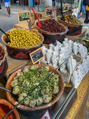 Selection of vibrant Mediterranean olives and spreads in a market setting. Offerings include various olives, seasoned spreads, and appetizer options, emphasizing fresh, authentic, and savory flavors.