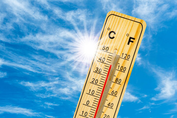 Auf einem Thermometer zeigt die Skala große Hitze - FOTOMONTAGE