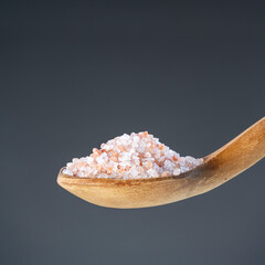 Heap of rose-colored sea salt on rustic wooden utensil, great for kitchen and mineral nutrition images