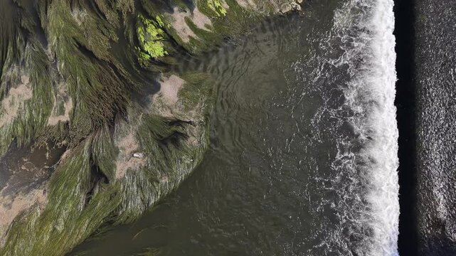 composition graphique au dessus d'une rivi&egrave;re avec de l'eau qui s'&eacute;coule &agrave; droite , une ligne de remous et des algues sur le c&ocirc;t&eacute; gauche