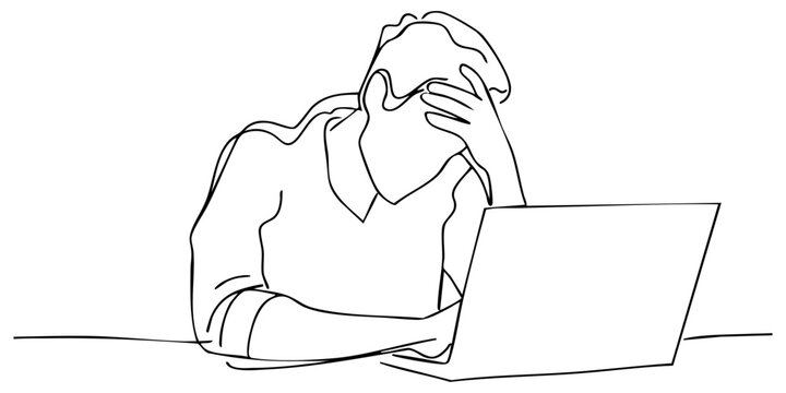 Person experiencing stress while working on a laptop at home during evening hours