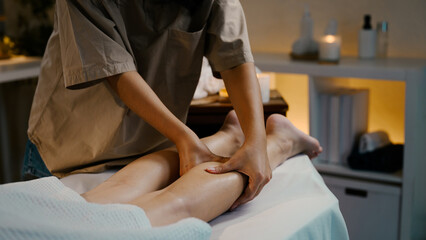 Professional masseuse giving leg massage in tranquil spa room