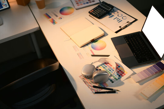 Creative designer workspace with color swatches, color wheel charts, and laptop