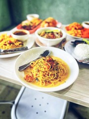 A delightful spread featuring golden soft-shell crab spaghetti, a vibrant plate of pasta with a rich, creamy sauce.
