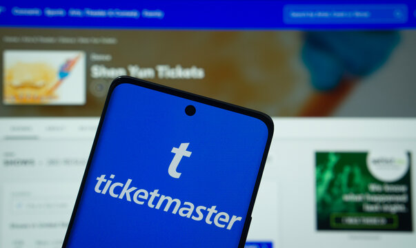 Dhaka, Bangladesh - 18 March 2025: The logo of the Ticketmaster is displayed on a smartphone screen, and the website Ticketmaster is visible on a computer screen in the background.