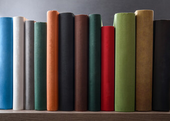 Naklejka premium Row of books showing various colored spines on a shelf