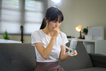 Young woman using respiratory exerciser to improve lung function and breathing capacity