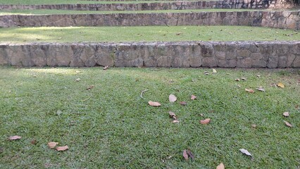 rocky seating in the garden and green grass in the evening