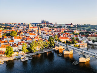 The sky brightens as the sun rises over Prague, casting golden light on the charming medieval...