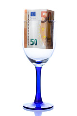 Fifty euro bill placed in wine glass on white background