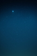 Obraz premium Starry night sky with vivid blue gradient and radiant bright star in cosmic atmosphere for backgrounds or prints, ideal for digital art or wallpapers, unique design Pro.