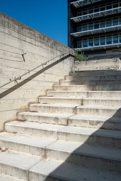 Concrete stair detail with sunlight and shadows, minimal lines and geometric composition in urban outdoor architectural context