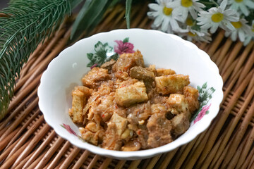 A bowl of Sambal Goreng Pengantin, a rich, traditional Malay dish made from a combination of beef liver, lung, trimmings, spleen, prawns, tofu, and tempe in coconut gravy, perfect for festive meals.
