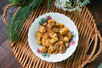 A bowl of Sambal Goreng Pengantin, a rich, traditional Malay dish made from a combination of beef liver, lung, trimmings, spleen, prawns, tofu, and tempe in coconut gravy, perfect for festive meals.

