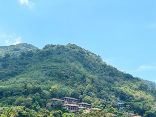 Stunning view of Karon, Phuket, Thailand, featuring lush green mountains and picturesque resort...
