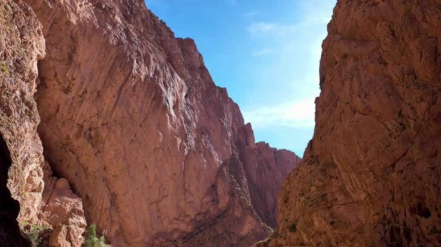 Tinghir, Morocco: Tilt down footage of tourists who take photo inside the Todgha gorge with locals selling various souvenir in the high atlas mountain in Morocco in north Africa. 