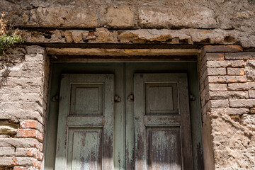 CLose-up to Old weathered wooden door on rustic stone wall in Erice, Sicily