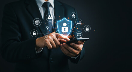 Cybersecurity concept. Businessman uses phone with holographic shield icon symbolizing data protection, online privacy, and secure user authentication.