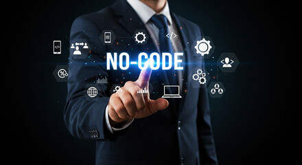 A man in a suit pointing at no code text with icons floating around on a dark background display screen