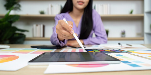 Graphic Design and Digital Creation. A designer using a tablet and color swatches to create visuals.