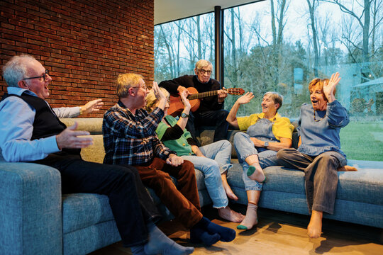 Group of senior friends enjoying music and fun at home