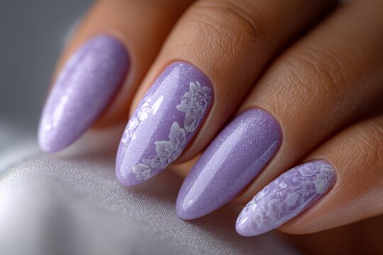 Close-up of a hand with long almond-shaped nails painted in sparkly lavender polish