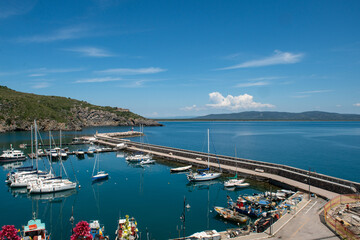 image that captures the charm of Porto Ercole, the sea, with its extraordinary maritime landscape, history and summer atmosphere. Inspiring landscapes rich in visual beauty and culture in Italy