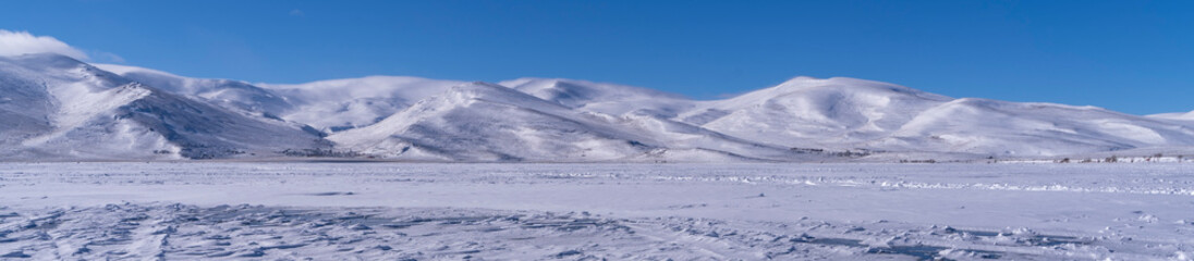 Panoramic Winter Majesty: Snow-Capped Mountains and Frozen Expanse