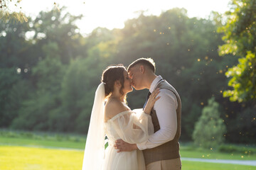 Picturesque wedding photo of the groom kissing the bride, with the back of the silhouettes...