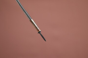 Close up Bendable Flexible Magnetic Pickup screw isolated on brown background, Claw Grabber Tool,...