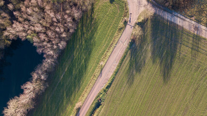 An aerial view reveals a picturesque winding path snaking through lush green foliage leading to a...