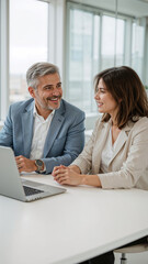 Fototapeta premium Business colleagues discussing a project together in an office setting using a laptop computer.