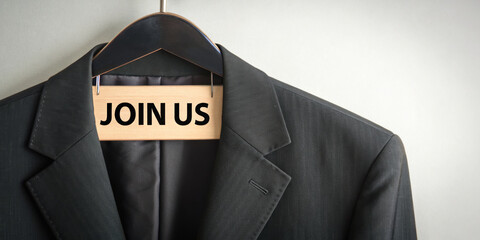 vacancy job. A suit jacket hangs on a hanger with a sign reading "JOIN US," suggesting a call to action or invitation to a professional opportunity.