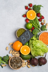 Top view of foods rich in vitamin B9 (folic acid) with vegetables, legumes, fruits and seeds. Healthy lifestyle and nutrition concept on light background.