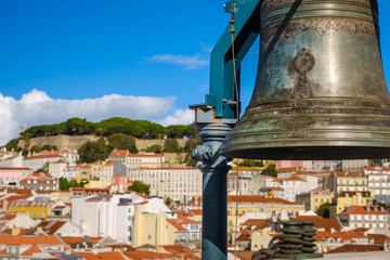 Historic bell with Lisbon cityscape and St Jorge castle on sunny day