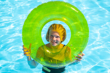 smiling girl looking through hole transparent Inflatable swim ring, float with cheerful face, Summer travel hotel vacation, Kid relaxing in pool. swimming in blue water. activity, watersports.