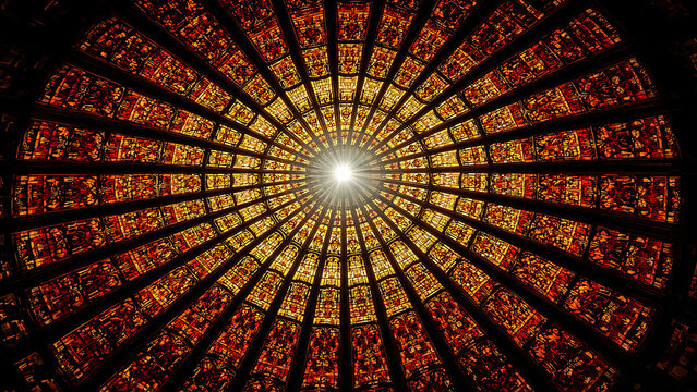 Stunning circular stained glass window with golden hues and bright central light