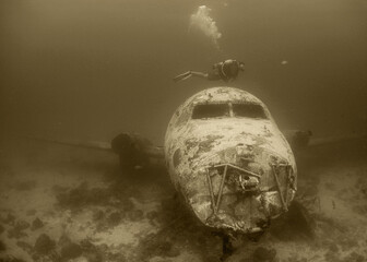 Wreck Diver Exploring Sunken Aircraft in Aruba's Vibrant Coral Reef