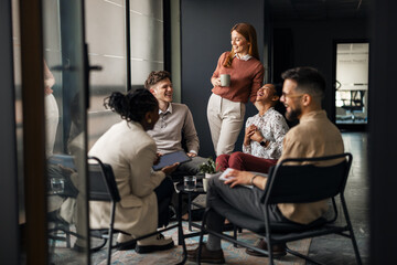 Group of Colleagues Sharing a Laugh in a Modern Office