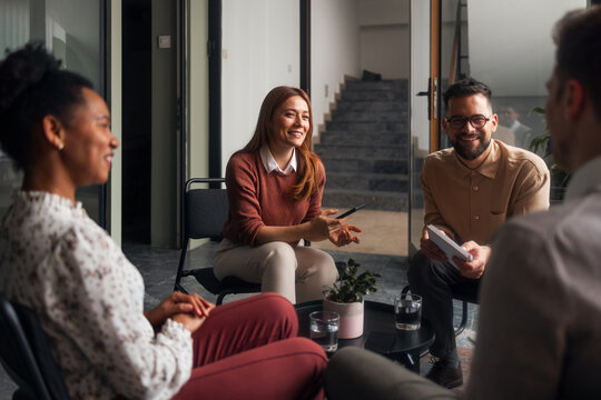 Group of Four People Having a Discussion in a Modern Office - Powered by Adobe