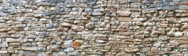 stone wall made of old cobblestones, gray brickwork background