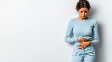 Young woman gripping her belly, visibly struggling with abdominal pain and discomfort, highlighting the challenges of digestive issues