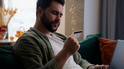 Caucasian man business male frustrated businessman guy homeowner work laptop typing computer holding credit card enter data transaction payment failure bad online fail connection access denied at home