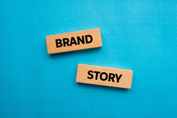 Brand story message written on wooden blocks on blue background. Conceptual brand story symbol. Copy space.