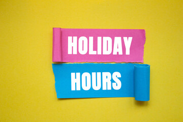 Holiday hours message written on ripped torn color paper pieces on yellow background. Conceptual holiday hours symbol. copy space.