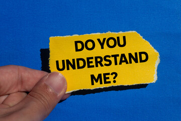 Do you understand me message written on ripped torn yellow paper piece on blue background....