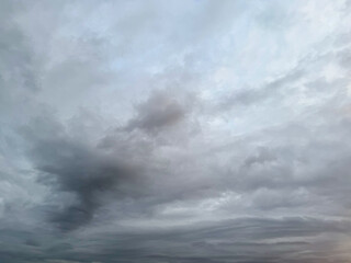 Obraz premium Dramatic clouds. Dark blue clouds swiftly floating across blue sky. Sky texture, abstract nature background. Stormy sky with dark, snowy clouds on a spring day. Clouds are floating across the sky.