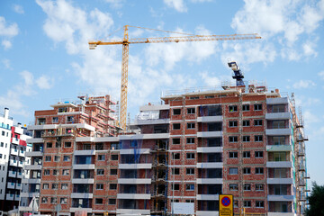 Construction crane building new residential apartments on a sunny day